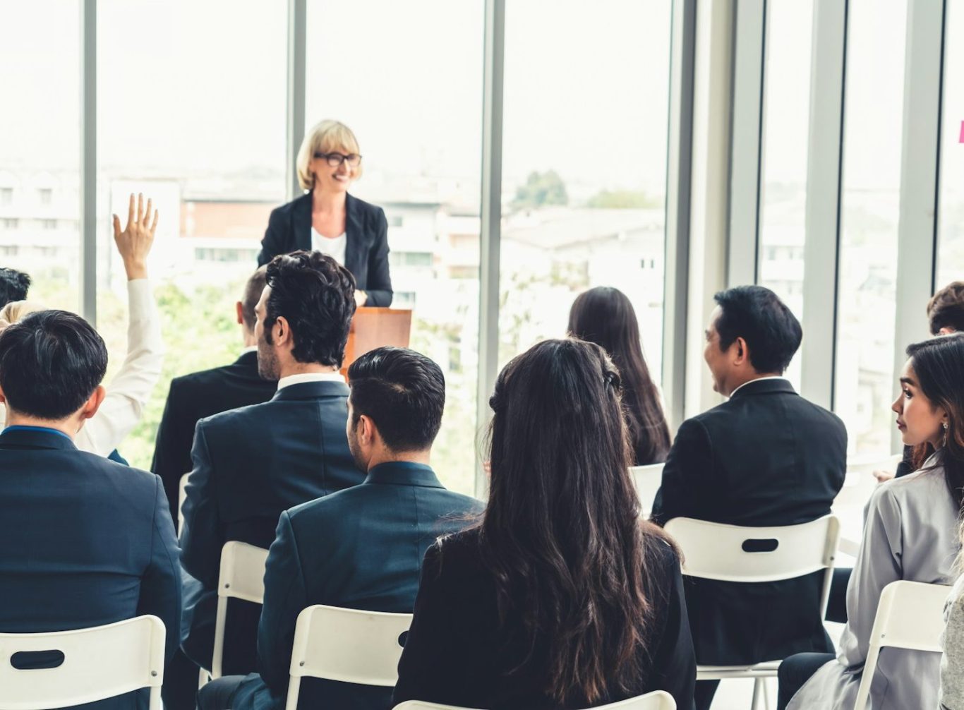 Lecturer presenting to a seated audience in a bright training room
